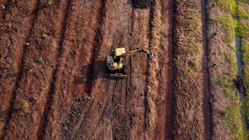 Excavator dig ground at construction site. Aerial view of a wheel loader excavator with a backhoe loading sand into a heavy earthmover. Excavator digging soil pits for the agricultural industry. video