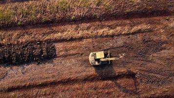 grävmaskin gräv jord på konstruktion webbplats. antenn se av en hjul lastare grävmaskin med en traktor läser in sand in i en tung jordflyttare. grävmaskin grävning jord gropar för de jordbruks industri. video