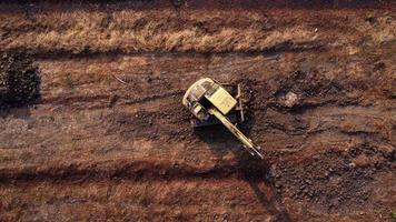 Excavator dig ground at construction site. Aerial view of a wheel loader excavator with a backhoe loading sand into a heavy earthmover. Excavator digging soil pits for the agricultural industry. video