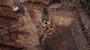 antenn se av en hjul lastare grävmaskin med en traktor läser in sand in i en tung earthmover på en konstruktion webbplats. grävmaskin grävning jord gropar för de jordbruks industri. video