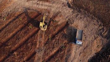 Aerial view of a wheel loader excavator with a backhoe loading sand into a heavy earthmover at a construction site. Excavator digging soil pits for the agricultural industry. video