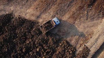 aereo Visualizza di cumulo di rifiuti camion versa suolo in il fossa a costruzione luogo. video