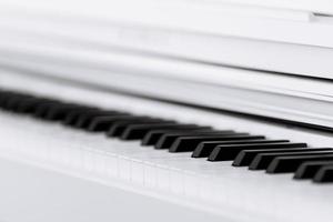 Close side view of shiny black and white piano keys with the reflection of the white edge from low angle with shallow depth of field. selective focus photo