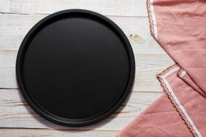 empty wooden round pizza tray and tablecloth on wooden background top view photo