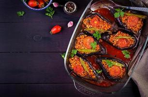 Karniyarik - turkish traditional aubergine eggplant meal. Stuffed eggplants with ground beef and vegetables baked with tomato sauce. Turkish cuisine. Top view. Copy space photo