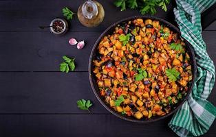 Ratatouille. Vegetarian stew  eggplants, bell peppers, onions, garlic and tomatoes with herbs.  Traditional french food. Top view. photo