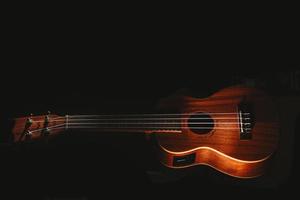 A ukulele on black background photo