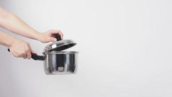 Pot cleaning Man hand on white background cleaning the non stick pot with handy dish washing sponge which yellow color on the soft side and green on hard side for hygiene after cook. Electric pot photo