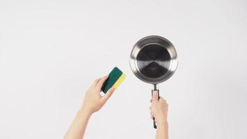 Pot cleaning Man hand on white background cleaning the non stick pot with handy dish washing sponge which yellow color on the soft side and green on hard side for hygiene after cook. Electric pot photo