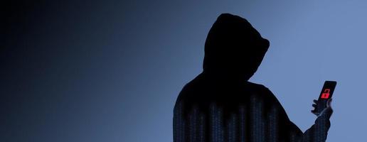 Hacker Anonymous and face mask with smartphone in hand. Man in black hood shirt holding and using mobile phone on white background. Represent cyber crime data hacking or stealing personal data concept photo