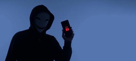 Hacker Anonymous and face mask with smartphone in hand. Man in black hood shirt holding and using mobile phone on white background. Represent cyber crime data hacking or stealing personal data concept photo