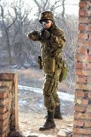 Soldier near wall with a gun photo