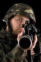 soldado listo apuntando con un rifle en el estudio foto