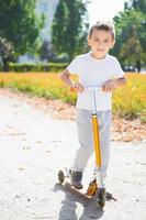 The boy rides along the path photo