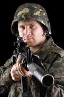 Soldier holding a gun in studio photo