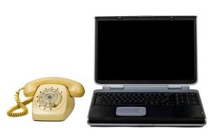 portátil y teléfono antiguo. aislado en blanco