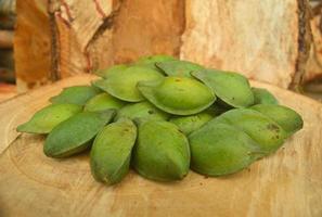 sumbawa, indonesia, 2023 - pila de frutos de terminalia catappa sobre fondo de madera foto