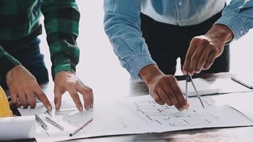 costruzione e struttura concetto di ingegnere o architetto incontro per progetto Lavorando con compagno e ingegneria utensili su modello edificio e planimetria nel Lavorando luogo, contrarre per tutti e due aziende. video