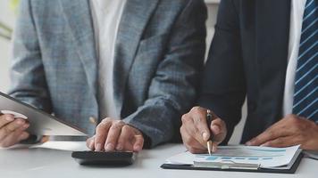 Financial analysts analyze business financial reports on a digital tablet planning investment project during a discussion at a meeting of corporate showing the results of their successful teamwork. video