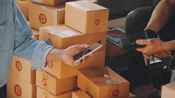 Unternehmer kleine Unternehmen KMU unabhängige Männer arbeiten zu Hause verwenden Smartphones und Laptops für kommerzielle Überprüfungen, Online-Marketing, Verpackungskartons, KMU-Verkäufer, Konzept, E-Commerce-Team, Online-Verkauf video