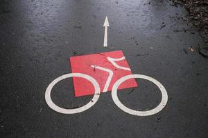 señal de bicicleta en la carretera bajo la lluvia foto