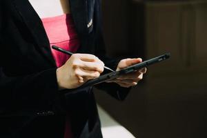 Mature businessman using a digital tablet to discuss information with a younger colleague in a modern business lounge photo