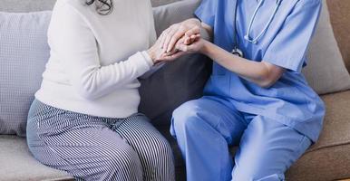 Homecare nursing service and elderly people cardiology healthcare. Close up of young hispanic female doctor nurse check mature caucasian man patient heartbeat using stethoscope during visit photo