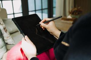 Mature businessman using a digital tablet to discuss information with a younger colleague in a modern business lounge photo