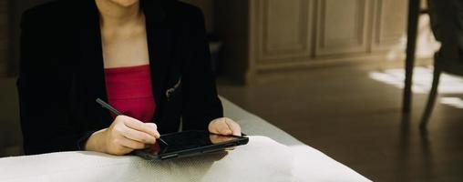 Mature businessman using a digital tablet to discuss information with a younger colleague in a modern business lounge photo