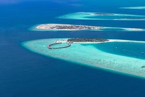 Aerial view of coral reefs in Maldives islands. Tropical aerial landscape. Luxury summer vacation and travel destination photo