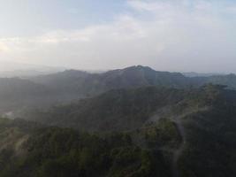 Aerial view of foggy forest landscape in Indonesia at sunrise. photo