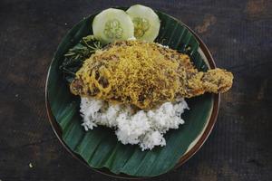 un retrato de un pez tilapia frito con arroz, verduras o lalapan y salsa picante o sambal foto