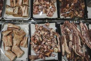 Categorized raw meat with bone on a storefront. Raw meat with beef bone. Beef bone selection for soup photo