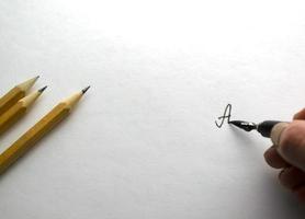 A woman writes with black ink on paper. photo