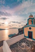 Great evening view of Santorini island. Picturesque spring sunset on the famous Greek resort Fira, Greece, Europe. Traveling concept background. Beautiful sunset landscape of famous vacation scenery photo