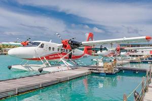 Male, Maldives - 14.08.19 Seaplane parking next to floating wooden pier, Maldives. Transmaldivian airways, world largest seaplane company photo