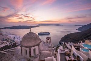 Great evening view of Santorini island. Picturesque spring sunset on the famous Greek resort Fira, Greece, Europe. Traveling concept background. Beautiful sunset landscape of famous vacation scenery photo