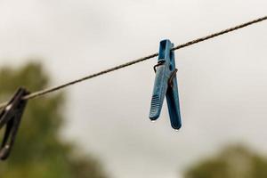 pinza para la ropa colgando de una cuerda. una pinza para la ropa cuelga del tendedero. fondo borroso foto