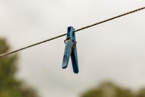 clothespin hanging from a rope. A clothespin hangs from the clothesline photo