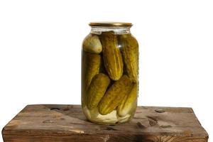 Canned cucumbers. Glass jar with cucumbers on a wooden board. white background. photo