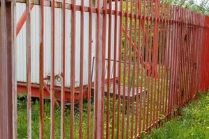 Red iron fence around the cellular station. Safety fence photo