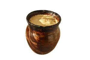 Clay pot with baked milk, isolated on white background. photo