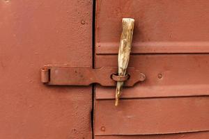 latch on the iron door. A wooden stick is inserted instead of a padlock. photo