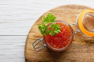 Red caviar with parsley in a jar photo