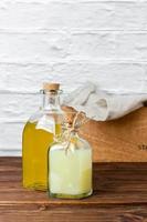Lemon and lime syrups in glass bottles on wooden table. photo