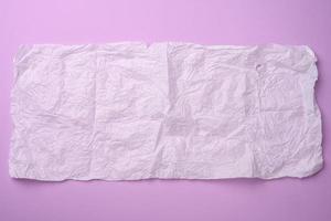 rectangular crumpled sheet of paper in tissue on a purple background photo