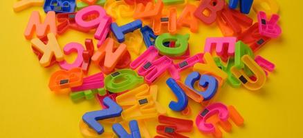 letras del alfabeto inglés de plástico multicolor con imán sobre fondo amarillo foto