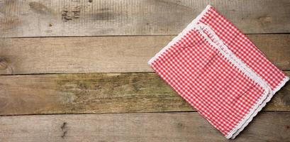 servilleta de cocina doblada de algodón rojo y blanco sobre un fondo gris de madera foto