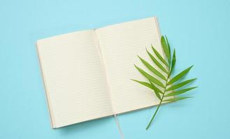open notebook with blank white sheets on a blue background, top view. photo