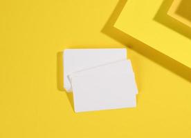 tarjeta de visita rectangular blanca en blanco sobre fondo amarillo creativo de hojas de papel con sombra foto